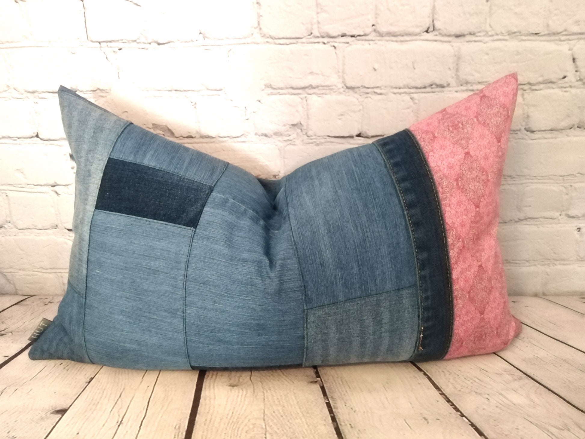 Handmade patchwork denim and pink Liberty fabric bolster cushion with feather inner pad.